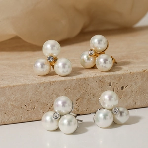 Elegant floral pearl stud earrings set with central rhinestone on a stone pedestal