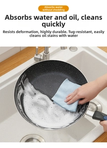 Detail of blue microfiber kitchen cloth cleaning a non-stick pan with rich foam