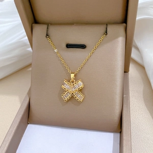 Macro detail of gold X-shaped pendant with baguette cut zircons in a jewelry box