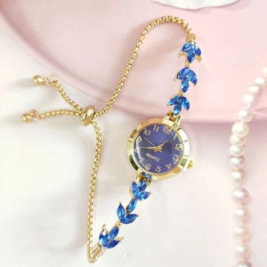 Détail d'une montre dorée pour femme avec cadran bleu et bracelet réglable en épis
