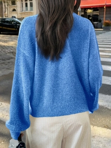 Détail arrière d'un pull en maille bleue en style urbain avec un éclairage naturel doux