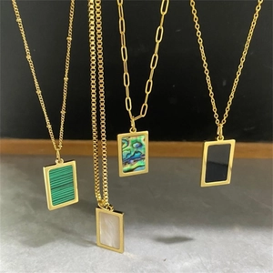 Cuatro colgantes rectangulares de acero bañados en oro con incrustaciones de nácar