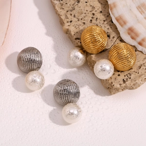 Detail of gold and silver double bead earrings with spiral metal and white pearls