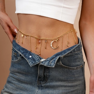 Detail of gold moon and star waist chain with rhinestones and faux pearls on blue jeans