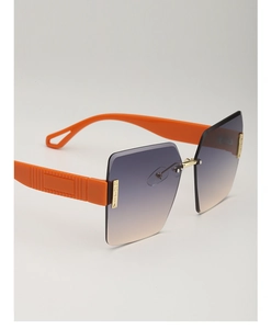 Close-up of frameless gradient lenses with orange temples and gold metal accents