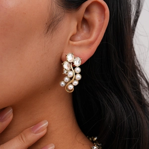 Macro shot of vintage gold earrings with faux pearls and sparkling rhinestones for women