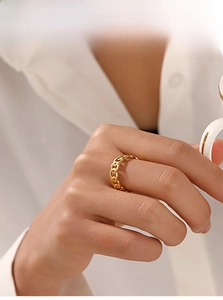 Close-up of a gold-plated stainless steel chain link ring worn on a finger