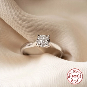 Macro shot of 925 sterling silver ring with cluster-set zircon on beige fabric