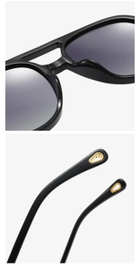 Detail of glossy black sunglass temples with gold cutout metal accents on tips