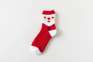 Close-up of thick Christmas socks with 3D Santa Claus character in red coral fleece