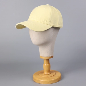Détail montrant la bordure en dentelle blanche sous la visière de la casquette jaune