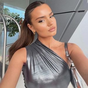 Sleek silver metallic one-shoulder dress paired with a matching shiny silver handbag
