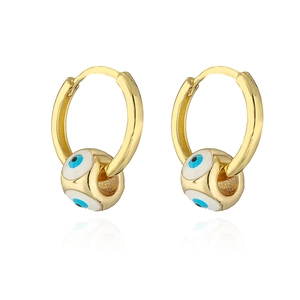 Close-up of gold-plated hoop earrings featuring blue enamel evil eye charms in detail