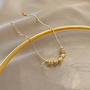 Elegant gold snake chain necklace featuring six frosted transition beads and lobster clasp