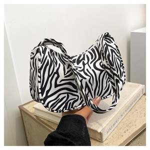 Gros plan du sac sous le bras en toile zébrée porté avec style par un mannequin