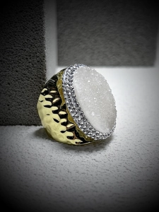 Detail of a gold hammered ring with white druzy quartz and small sparkling crystals