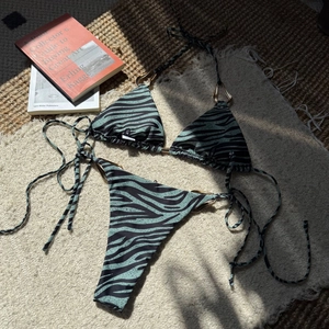 Detail of zebra print bikini with large golden metal rings and side-tie bottom