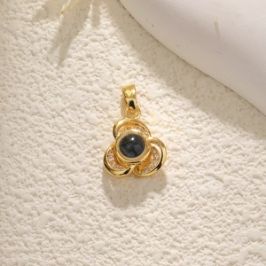 Close-up of a gold clover pendant featuring a black center stone and micro-pave diamonds