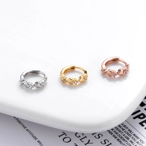 Detailed view of copper zircon earrings in silver, gold, and rose gold with heart motifs