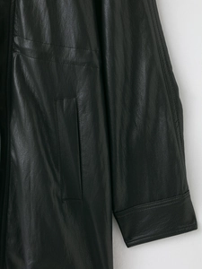 Macro view showing fine leather texture and stitching detail on black jacket sleeve