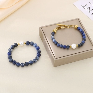 Detail of blue marble stone beads with single pearl and golden toggle clasp hardware