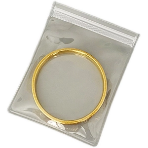 Eco-friendly EVA zip lock storage bag containing a polished gold bangle bracelet