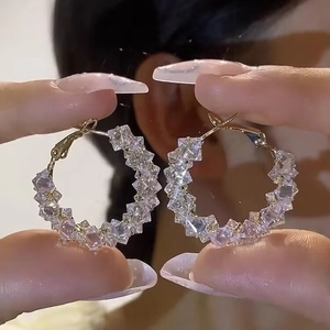 Close-up of luxury gold hoop earrings with sparkling square cubic zirconia stones