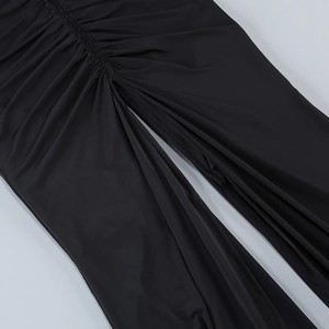 Dettaglio dell'abito bodycon nero arricciato con tessuto elastico a pieghe e spacco frontale