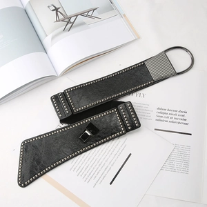Detail of black leather punk belt with silver metal rivets and D-ring buckle