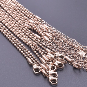 Macro detail of 18k rose gold bead chain showing S925 hallmark and lobster clasp