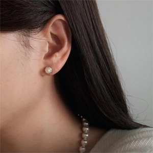 Close-up of model wearing 925 sterling silver pearl stud earring with elegant metal base