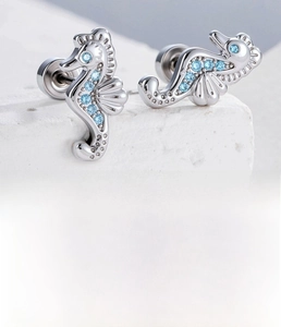 Detailed macro view of silver seahorse stud earrings with micro-set blue zircon stones