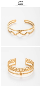 Detail of adjustable gold stacked bangles featuring heart patterns and star charms
