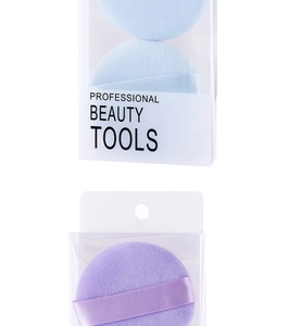Close-up of light blue and purple makeup powder puffs in professional plastic box packaging