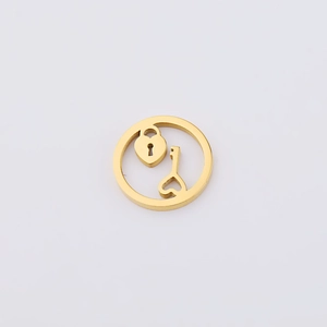 Macro shot of gold hollow circular pendant with heart-lock and key charm for jewelry making