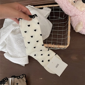 Detail of ruffled cuff socks with heart pattern and soft cotton texture for women