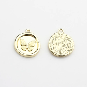 Detail of gold-plated butterfly pendant showing embossed pattern and dotted texture back