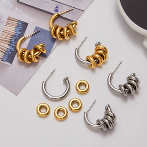 Flat lay of 18K gold and silver mixed C-shaped hollow earrings with multiple ring charms