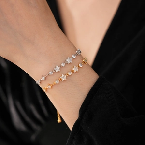 Detailed view of silver and gold star-shaped bracelets with sparkling white cubic zirconia