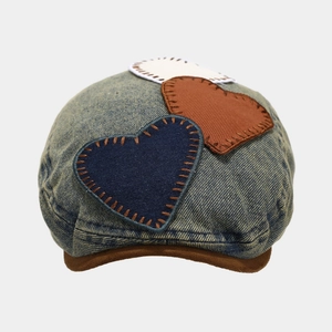 Detail of layered heart patches and stitching on vintage washed denim beret hat