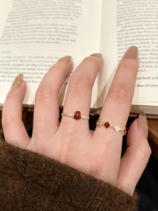 Close-up of elegant 18k gold plated gourd rings worn over a vintage book background
