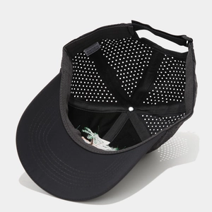 Detail of breathable laser-cut holes and 100% polyester lining on a black baseball cap