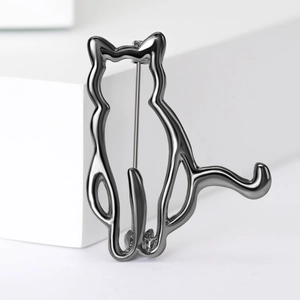 Macro detail of gunmetal cat silhouette brooch with polished smooth metallic finish