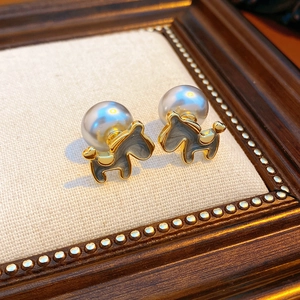Close-up of 18K gold-plated puppy earring with grey pearl and enamel detail