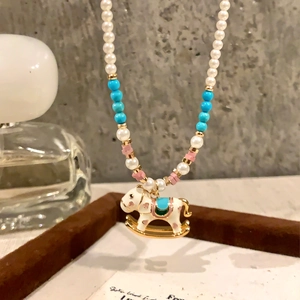 Elegant pearl necklace with a colorful rocking horse pendant and vibrant beads