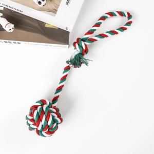 Macro detail of red, white, and green braided cotton rope dog toy for chewing and fetching