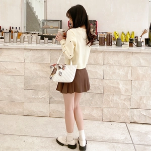 Fashionable white quilted tote bag with silk scarf paired with autumn embroidery knitwear
