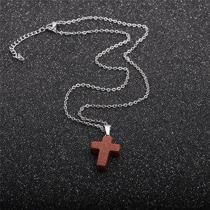 Minimalist stainless steel necklace featuring a brown goldstone cross pendant on O-chain