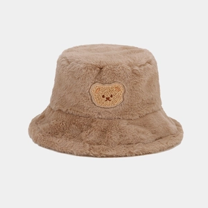 Close-up of plush brown bucket hat featuring a cute bear embroidery and thick faux fur texture