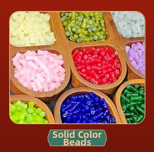 Macro detail of colorful bamboo-shaped glass beads in a wooden storage tray for DIY jewelry